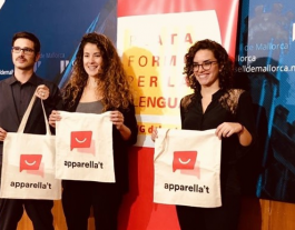 Tres participants en la iniciativa mostren bosses de roba amb el seu logotip