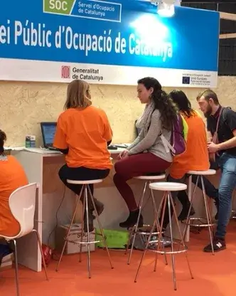 Joves assessorant-se en l'estand del SOC en el primer Saló de l'Ocupació Juvenil