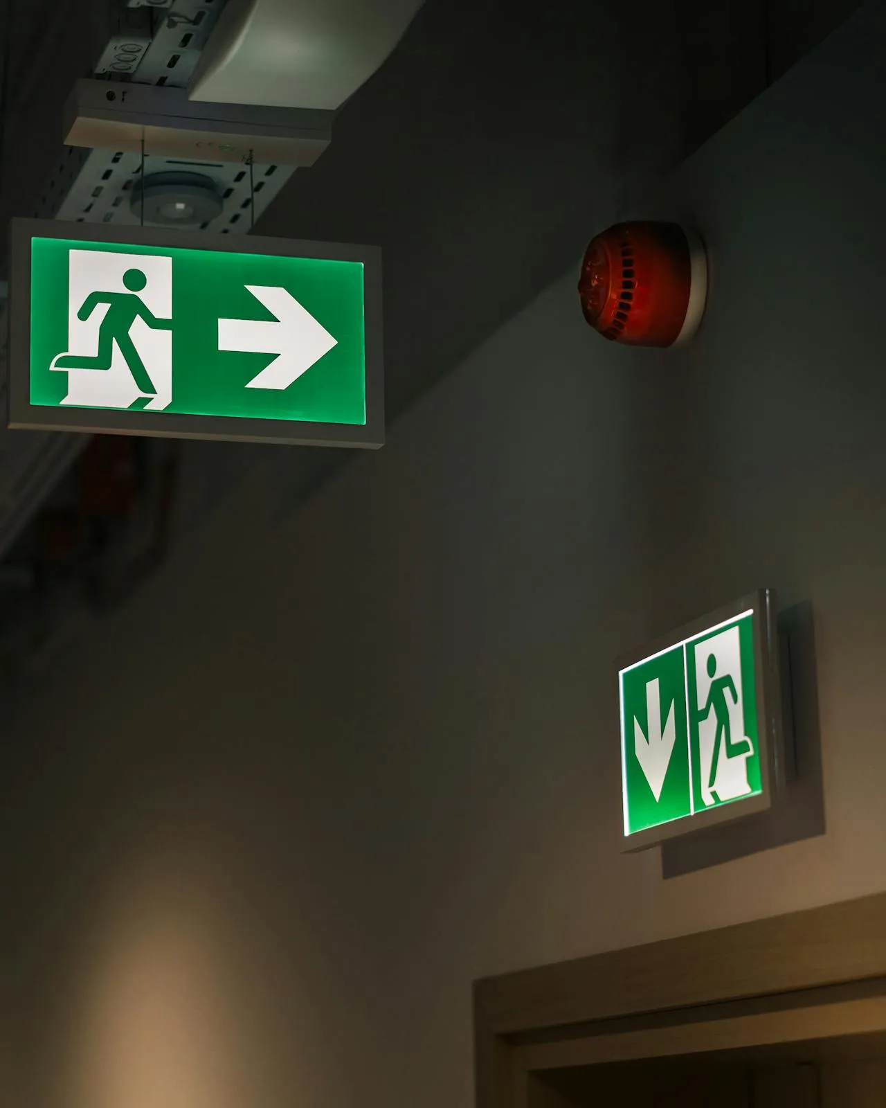 Passadís amb cartells indicant la sortida d'emergència Passadís amb cartells indicant la sortida d'emergència