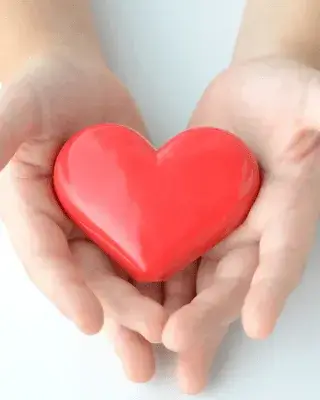 Dues mans sostenen un cor vermell, símbol de solidaritat i suport a causes socials.