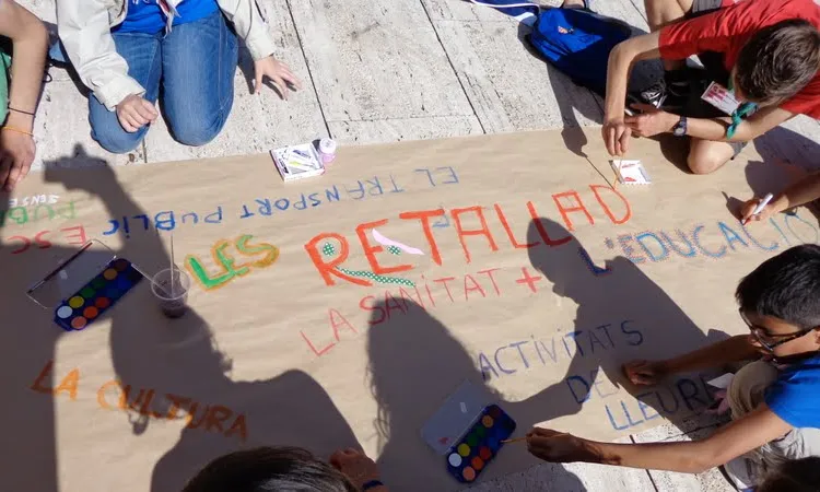 Nois i noies fent un cartell durant la trobada "Macedònia". Foto: MEG