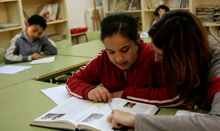 Una voluntària ajudant una de les nenes a l'escola Xarrau (Font: FAS)