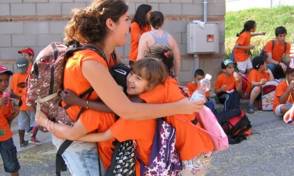 Voluntària abraçant-se amb nenes del CROMA a una de les sortides a la UAB (Font: FAS)