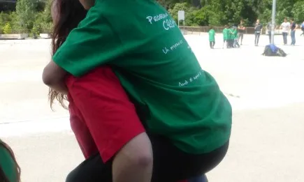 Voluntària amb una nena penjada a l'esquena (Font: FAS)