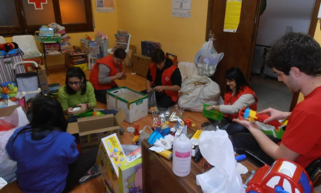 Voluntaris i voluntàries de Creu Roja Joventut Lleida classificant joguines