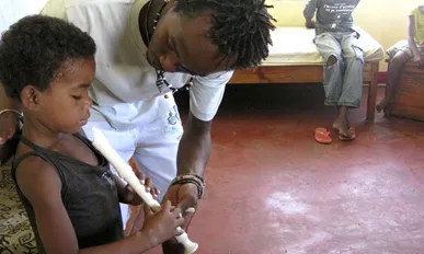 Imatge d'un nen aprenent a tocar la flauta. Font: Fundació Agua de Coco