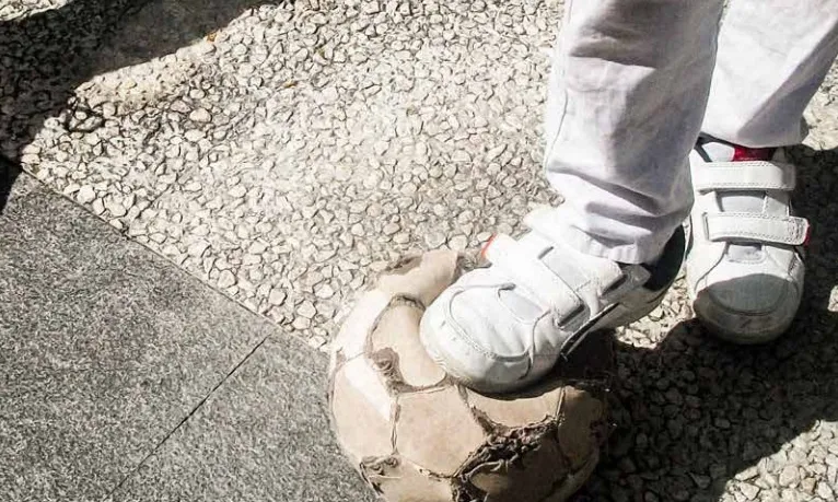 Infant jugant a pilota amb material vell. Font: Save the Children