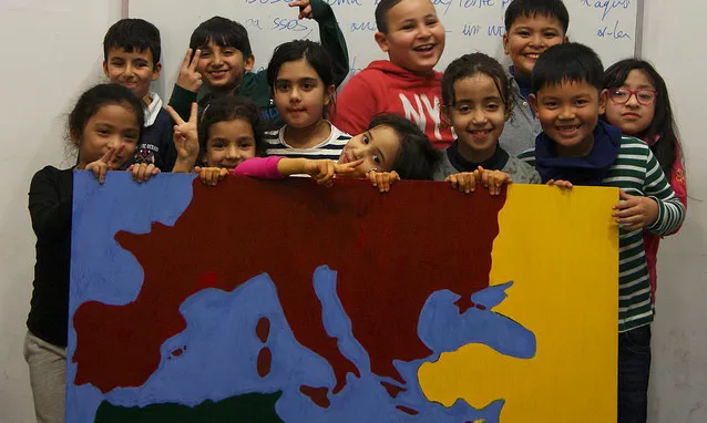 Els nens i nenes que participen al projecte mostren un mapa que han creat