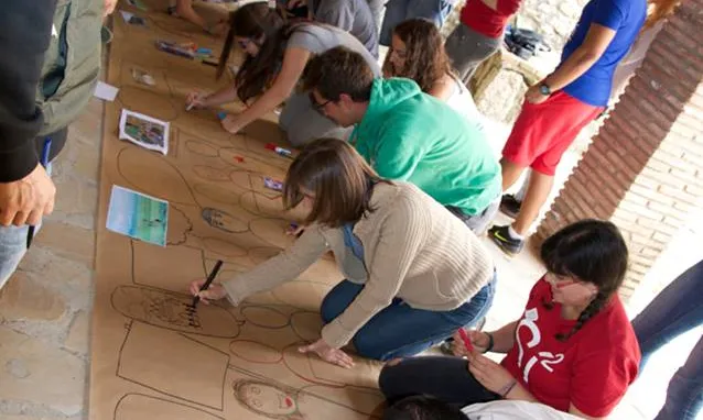 Grup de joves pintant un mural, en una activitat de l'SCI-Cat