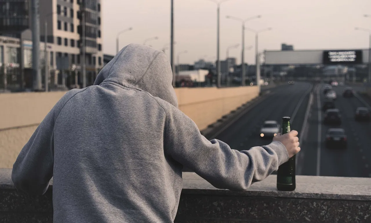 Imatge d'una persona amb una botella d'alcohol