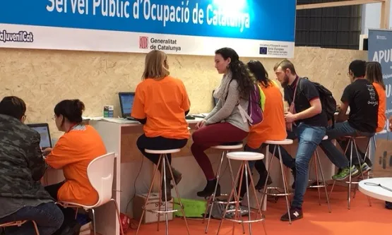 Joves assessorant-se en l'estand del SOC en el primer Saló de l'Ocupació Juvenil