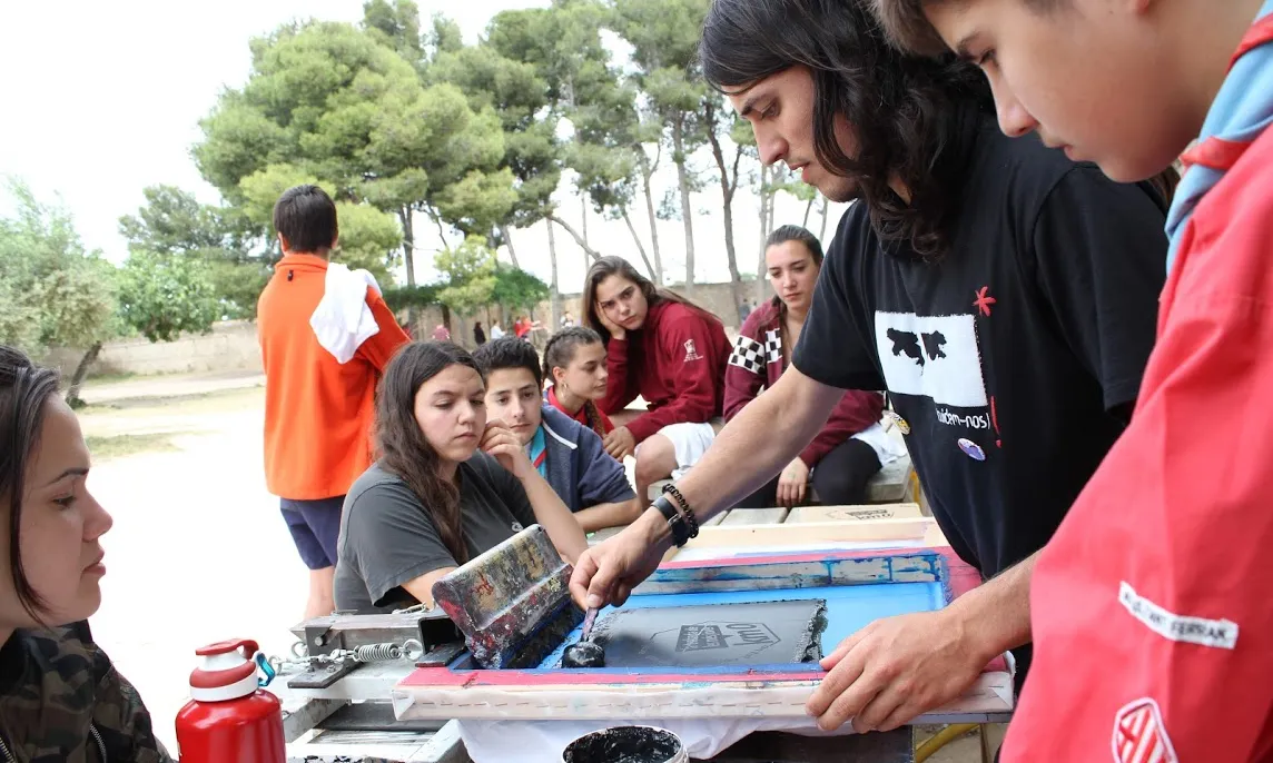 Joves participants a la trobada Km.0 durant un taller de serigrafia