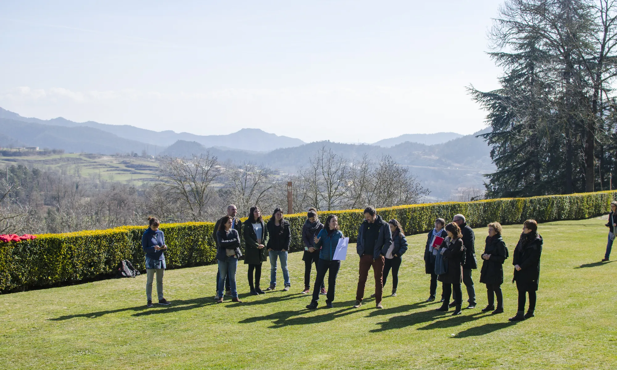 Els membres de l'assemblea surten al jardí de fora del Castell de Montesquiu per fer una dinàmica participativa per escollir el nom de la nova entitat. Fan diversos grups i una persona representant del grup explica els seus arguments per l'elecció del nom