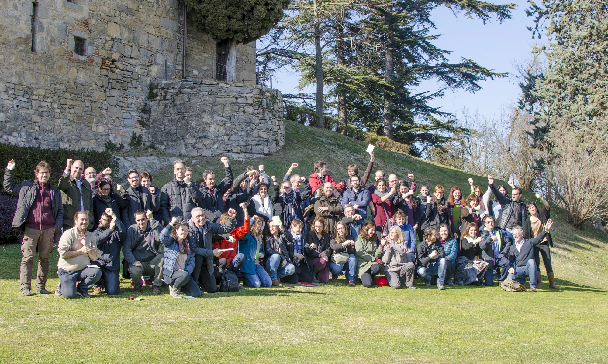 Els membres assistents, al voltant de 70 persones, posen tots junts davant la càmera i aixequen el braç per mostrar el braçalet verd de la Setmana Natura.