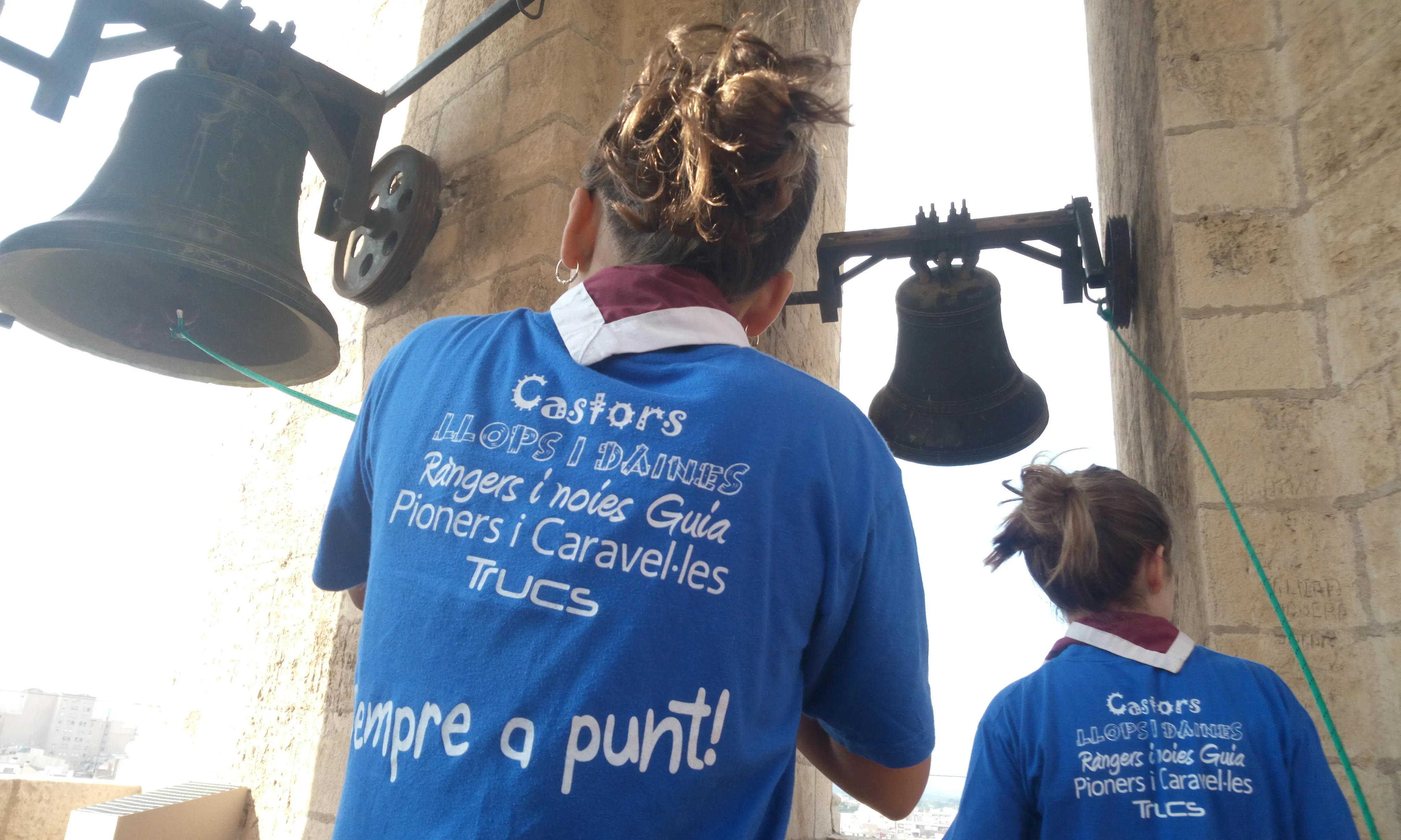 Dues noies toquen les campanes del campanar de Reus.