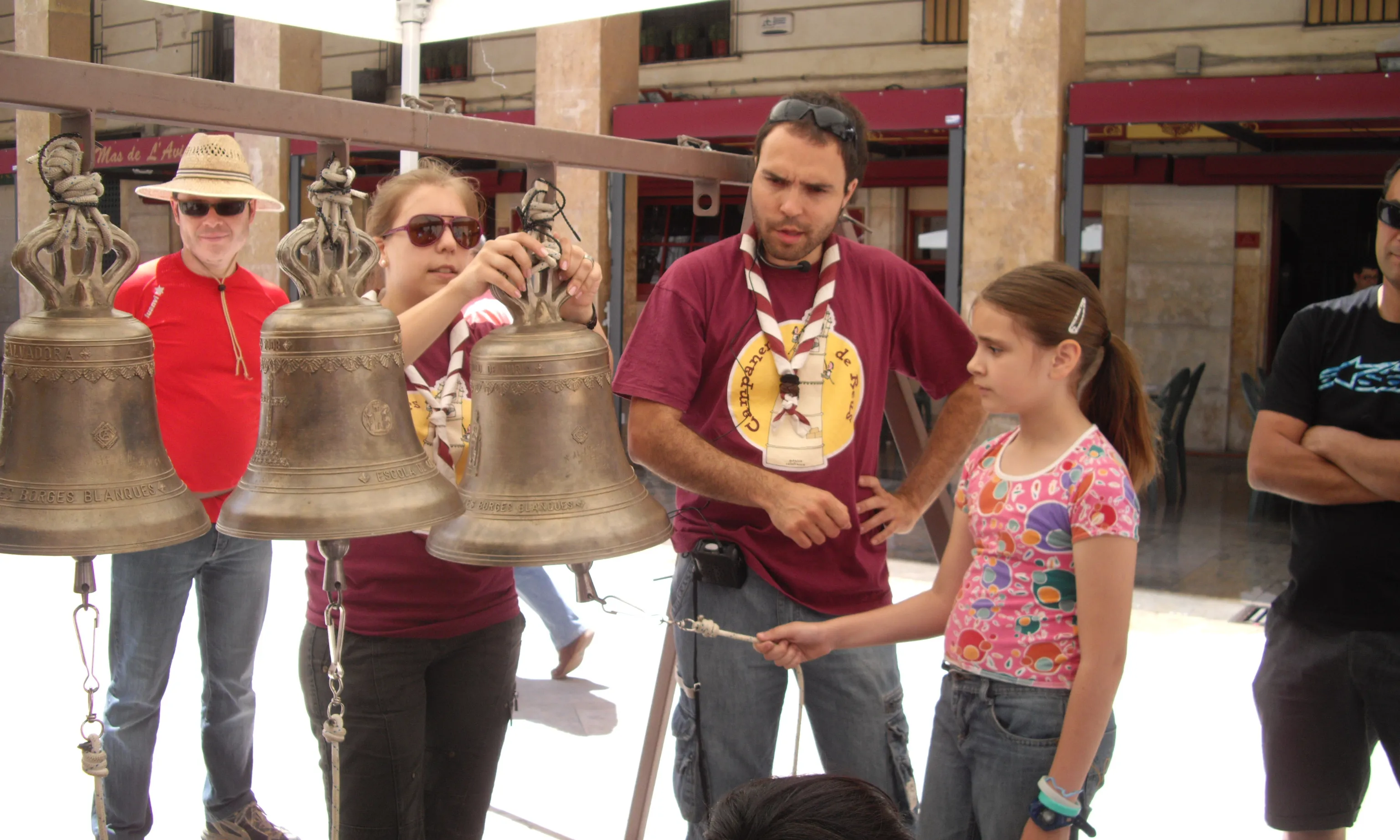 Membres dels Campaners de Reus ensenyant a infants com tocar les campanes.