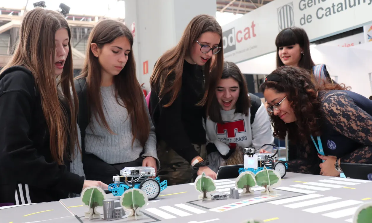 Un grup de noies participant en l'activitat de robòtica proposada per la cooperativa Colectic en el seu estand de yOMO Barcelona 2019