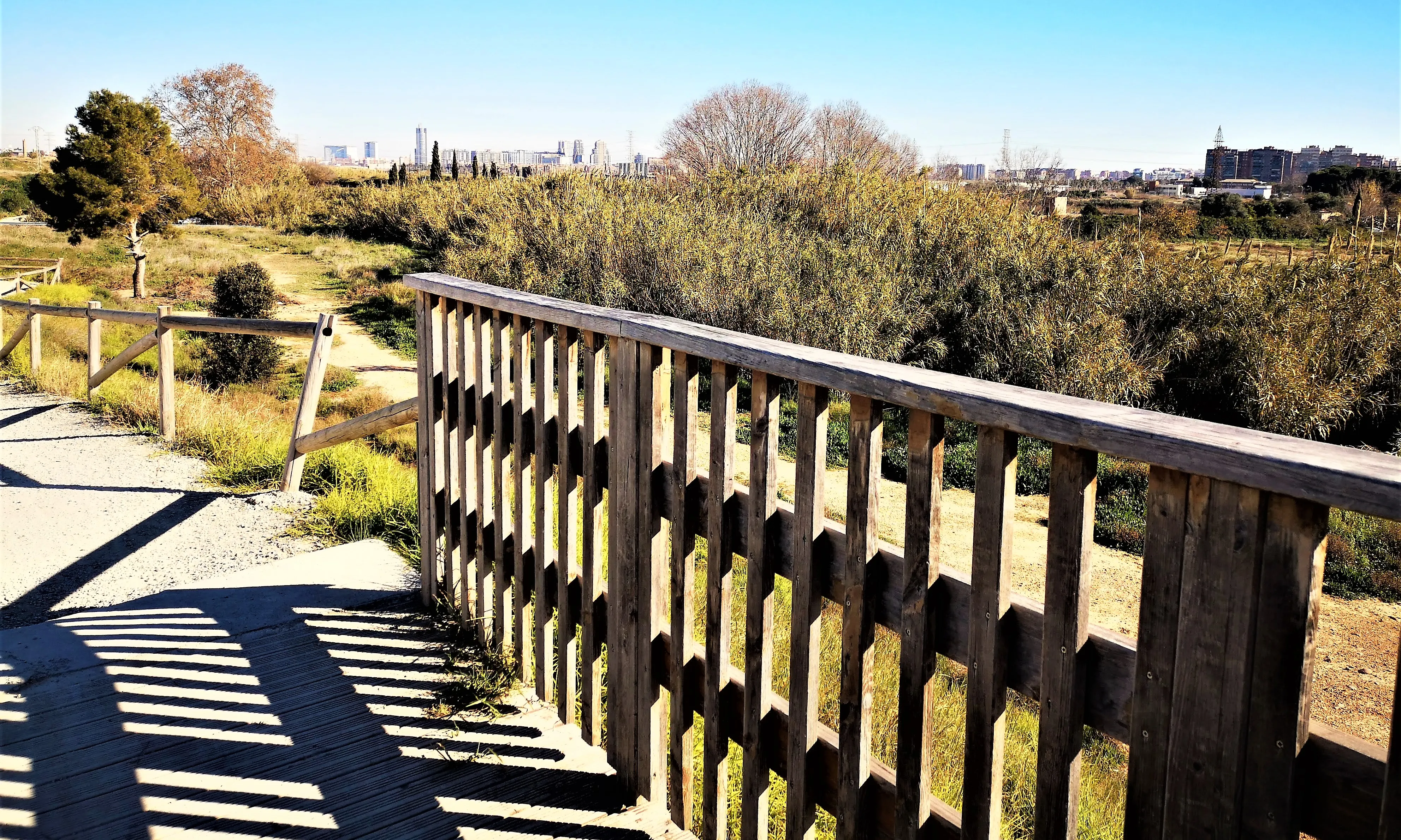 Vista d'un pont de fusta amb una ciutat al fons