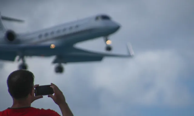 Fotografia d'una persona fent una fotografia a un avió