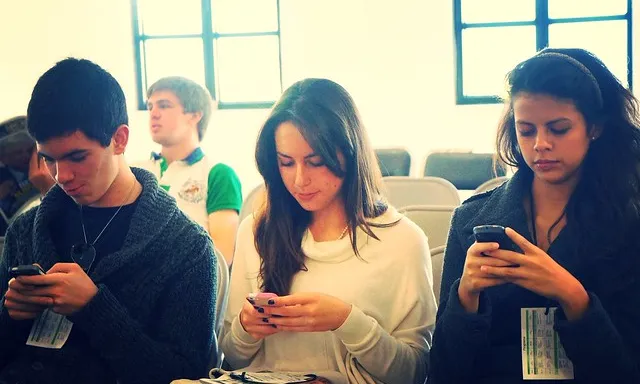 Fogotafia d'uns nois i noies utilitzant telèfon mòbil. 