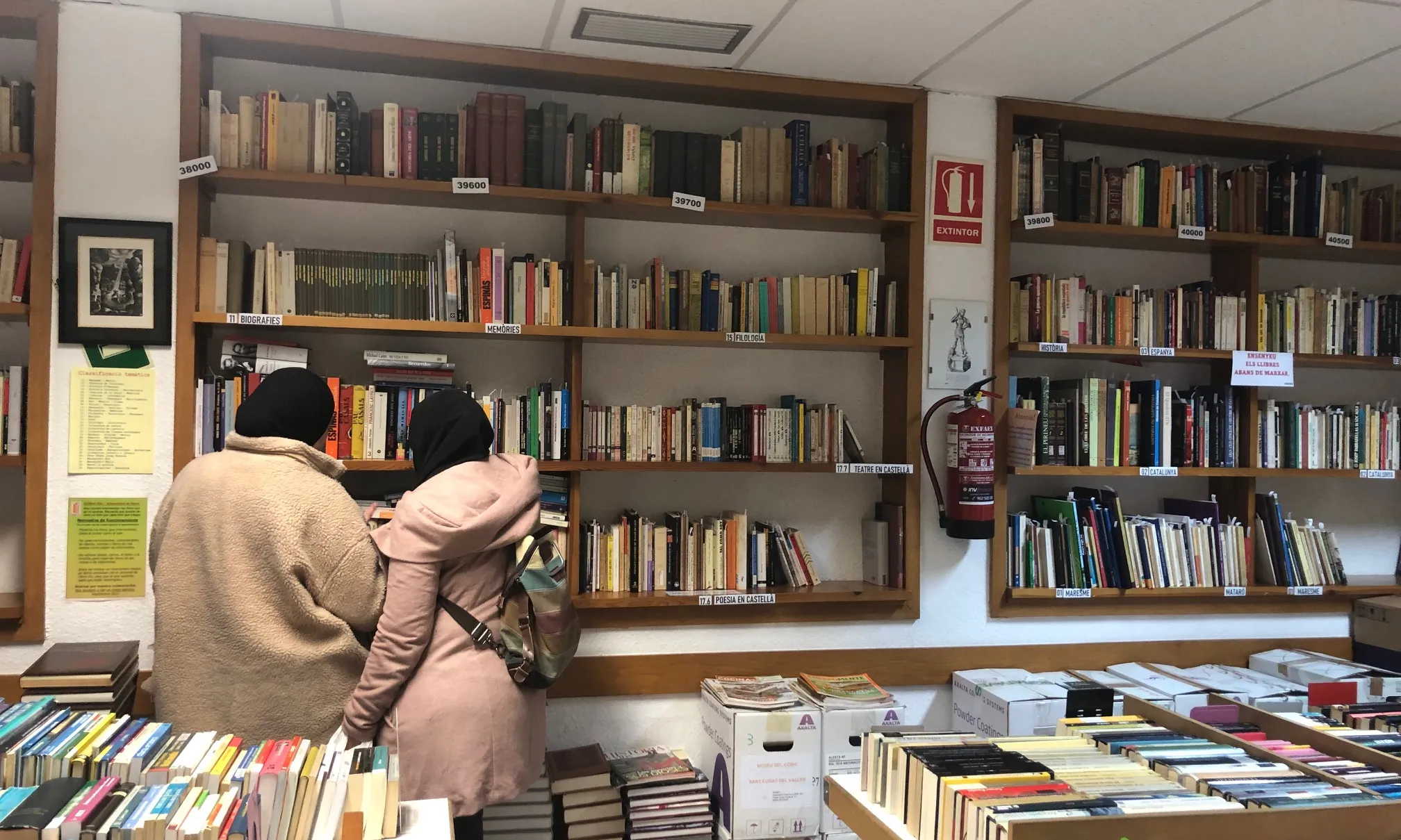 Veïns i veïnes del barri de la Rocafonda, de Mataró, s'apropen al local de l'entitat per cercar llibres i fer intercanvis.