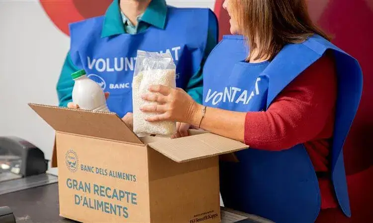 Foto de dues persones voluntàries participant en el Gran Recapte.