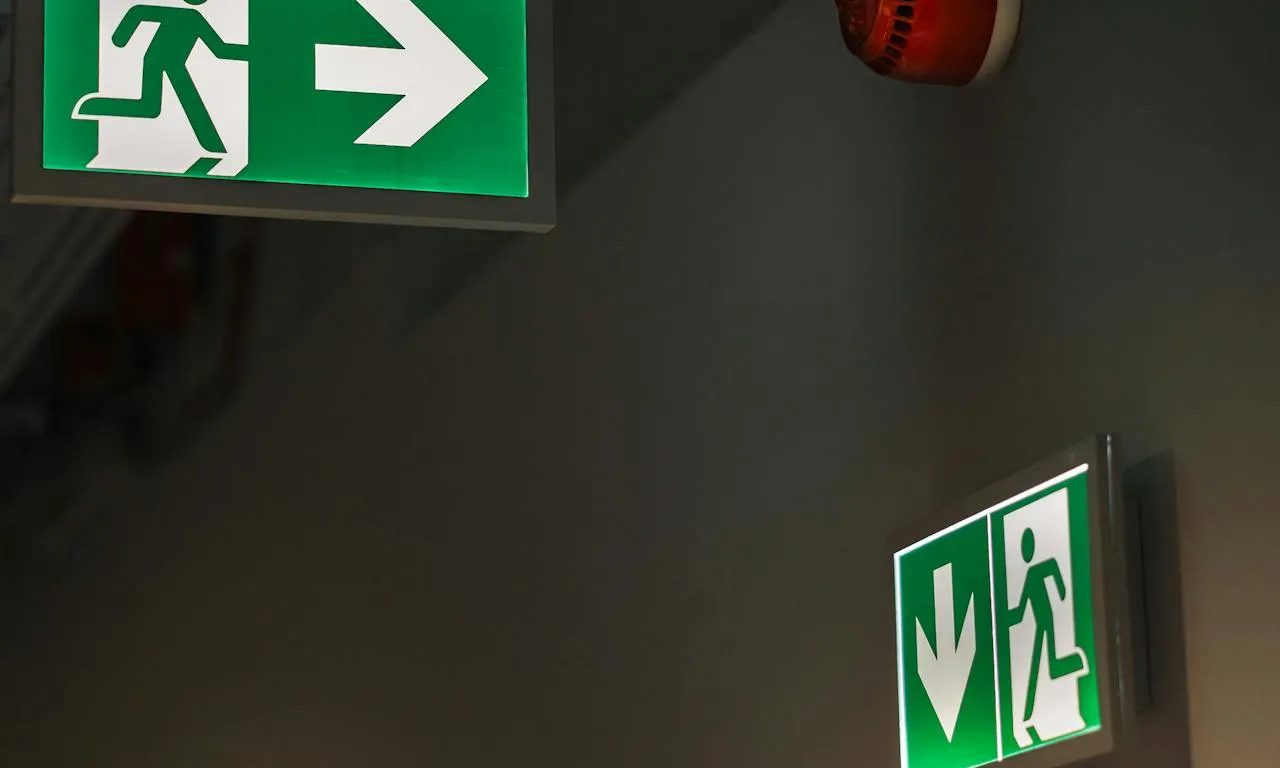 Passadís amb cartells indicant la sortida d'emergència Passadís amb cartells indicant la sortida d'emergència