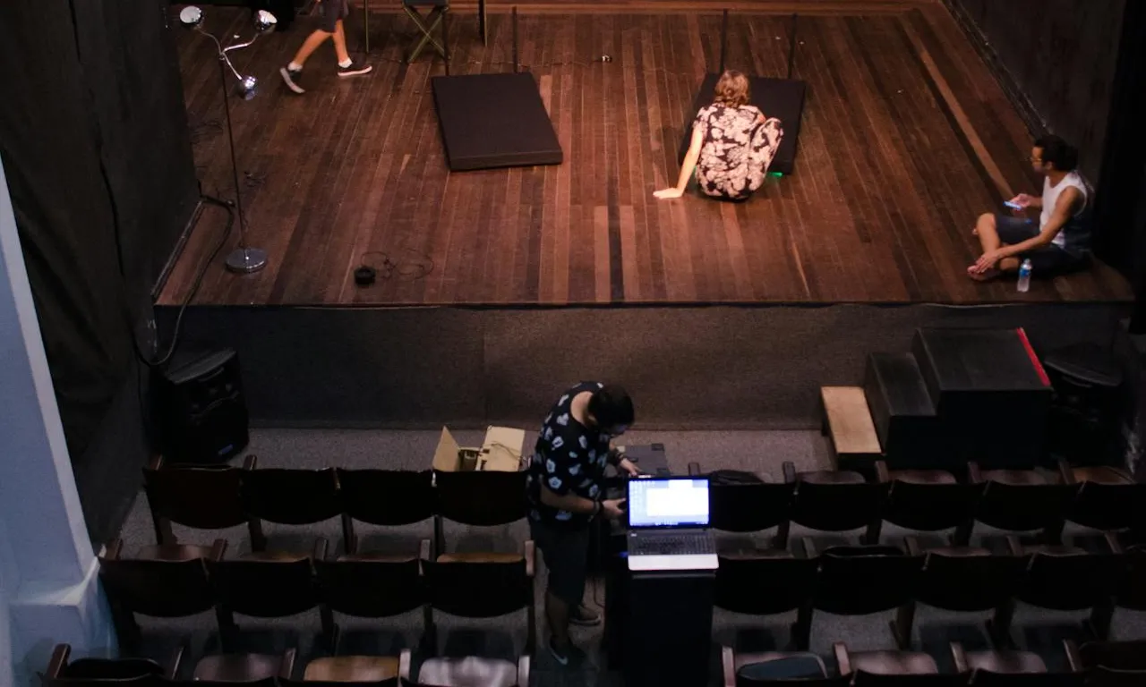 Vista zenital de les butaques i l'escenari d'un teatre amb gent treballant