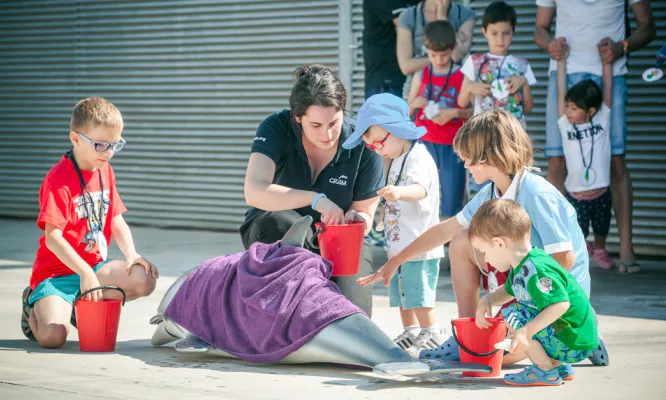 Infants cuidant un dofí.