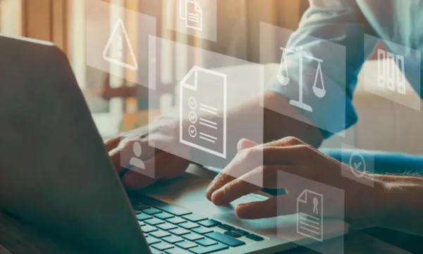 Persona utilitzant un ordinador portàtil amb icones digitals relacionades amb documents legals, normativa i gestió jurídica.