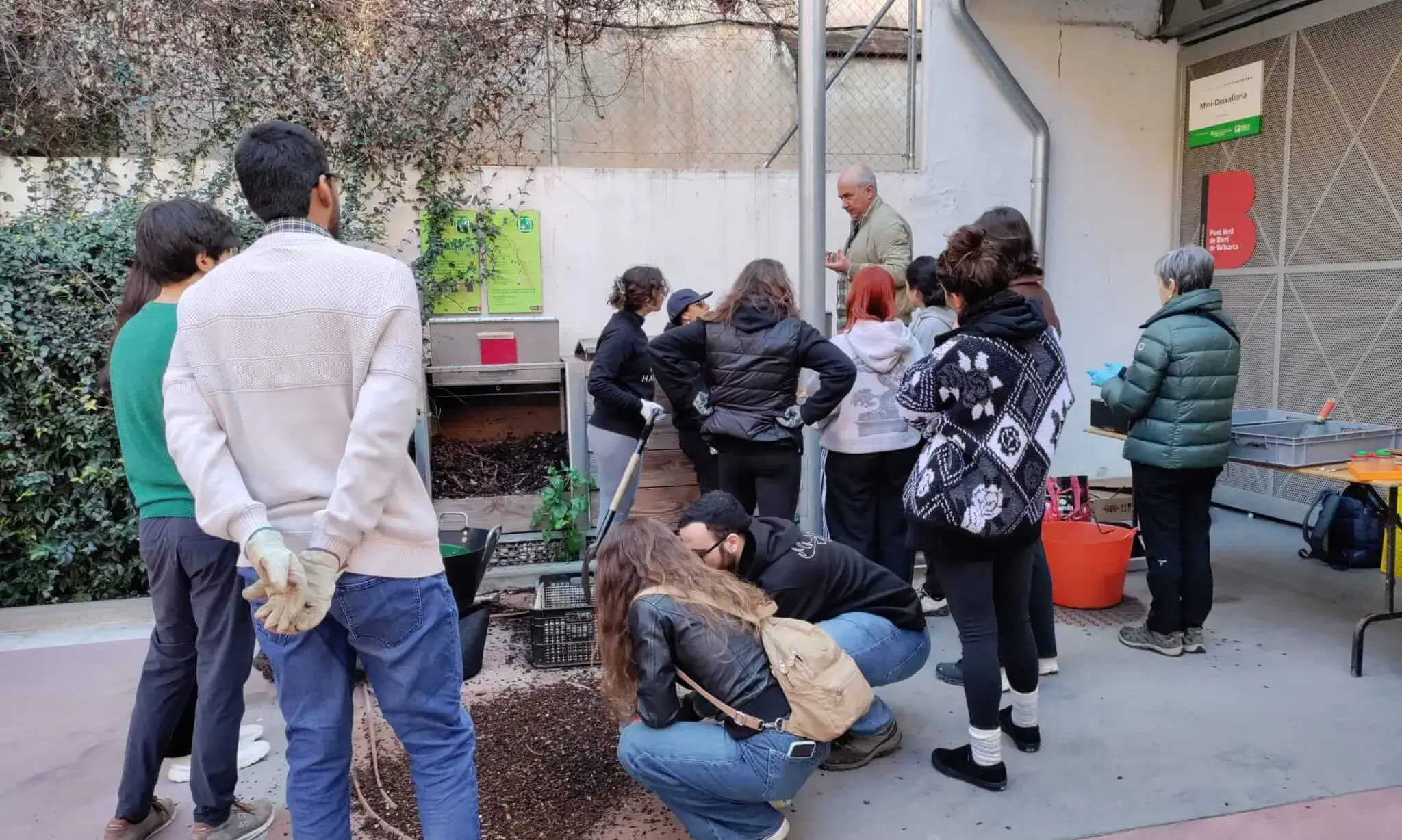 Imatge de la darrera jornada d¡obtenció de compost al Punt Verd de Barri Vallcarca, amb un grup nombrós de persones durant el procés d'obtenció del compost.