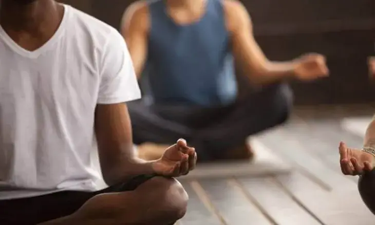 Imatge amb persones asseguedes amb les cames creuades i amb el dit polze i inicial fet in rodona