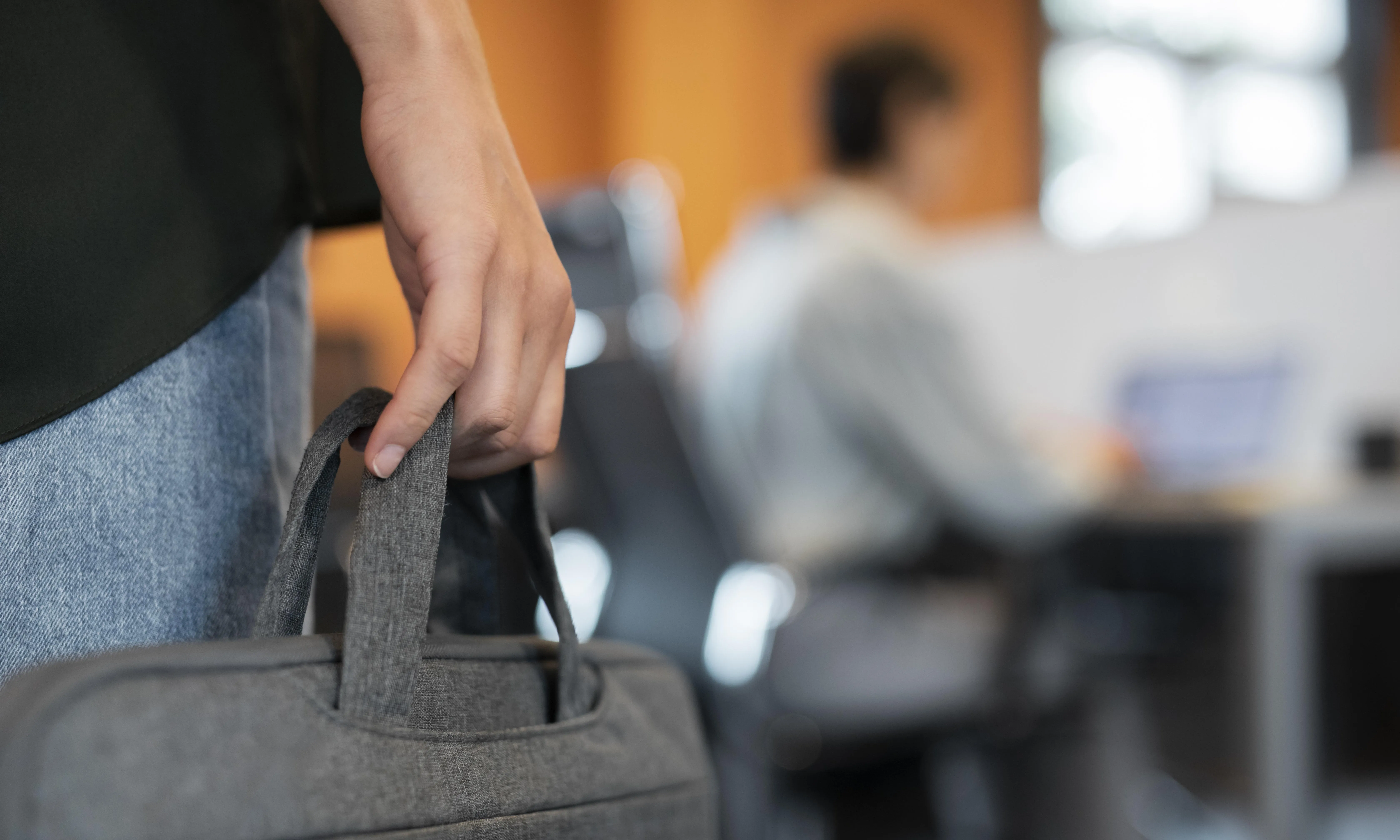 Una persona amb una maleta a la mà que torna a l'oficina.