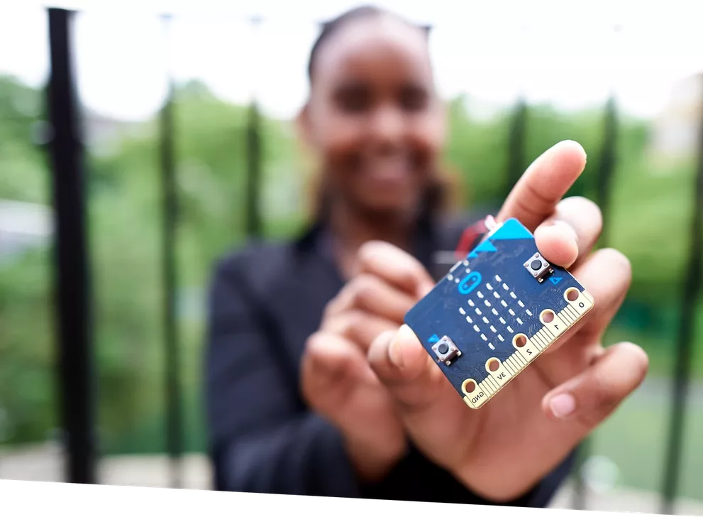 Una noia mostrant una placa de micro:BIT. Font: Micro:BIT