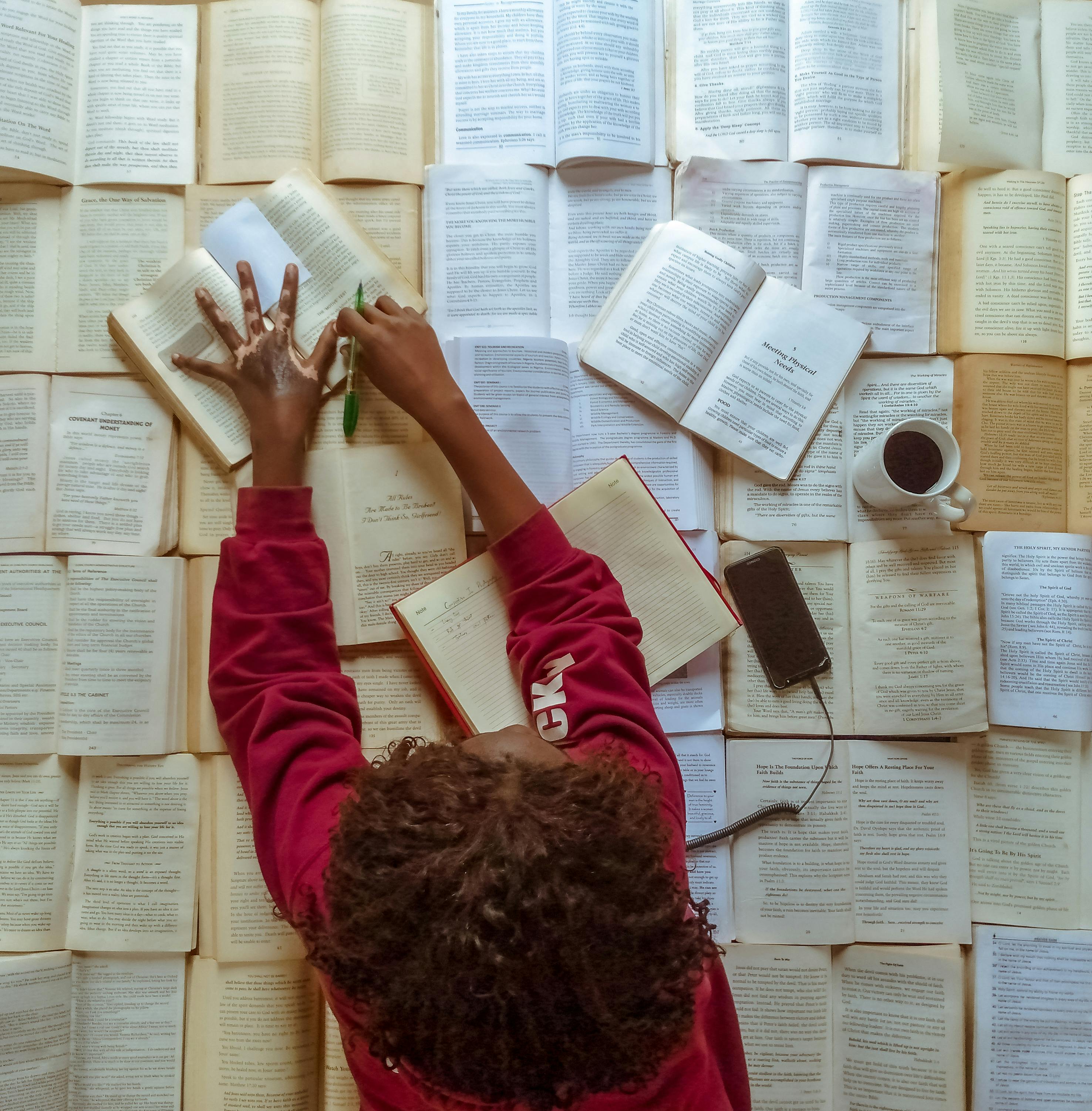 Persona llegint molts llibres. Font: Pexels - Adegbenro Emmanuel