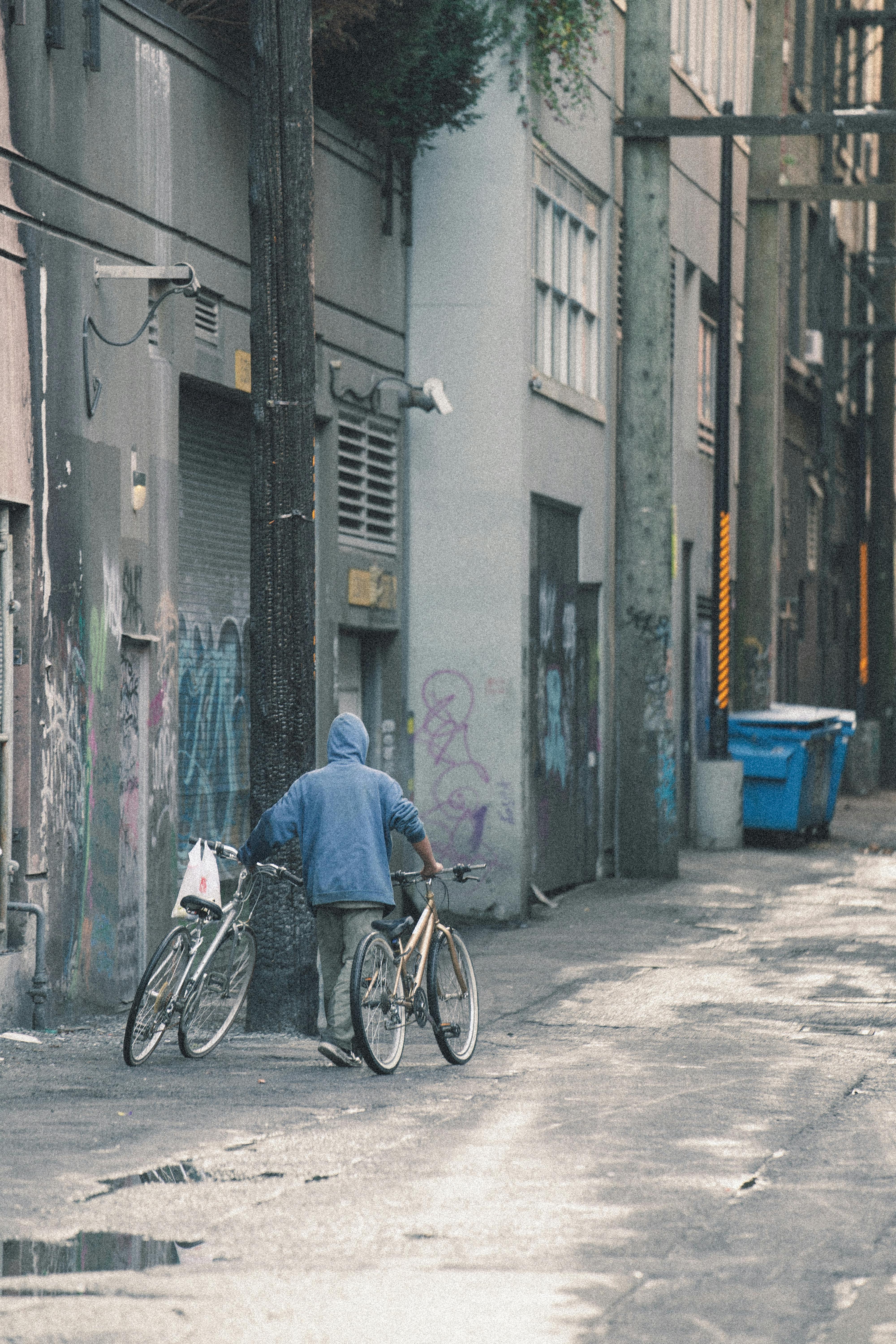 Persona portant a la mà dues bicicletes. Font: Pexels - Arnet Xavier