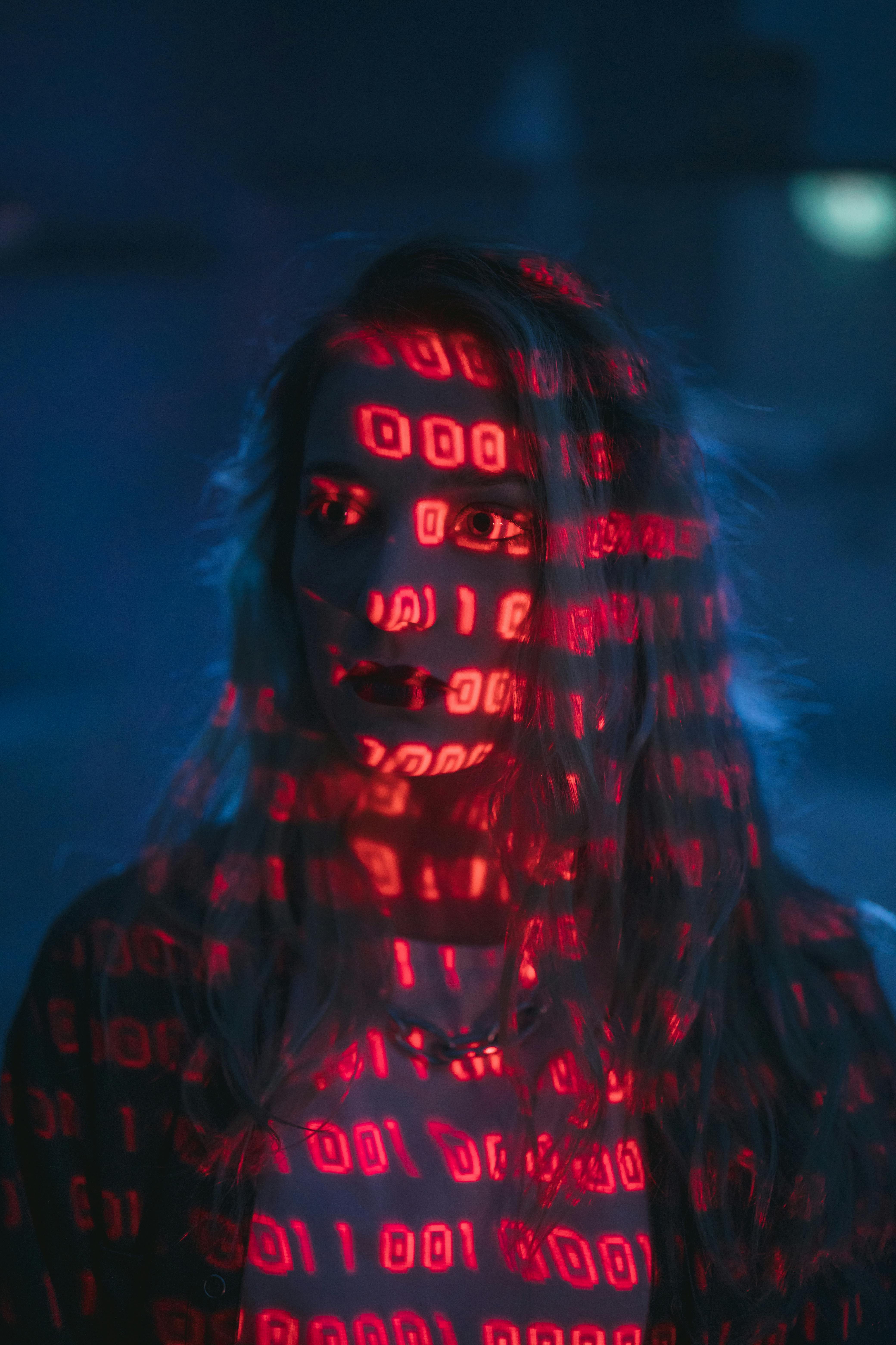 Noia amb codi binari que l'il·lumina. Font: Pexels - cottonbro studio