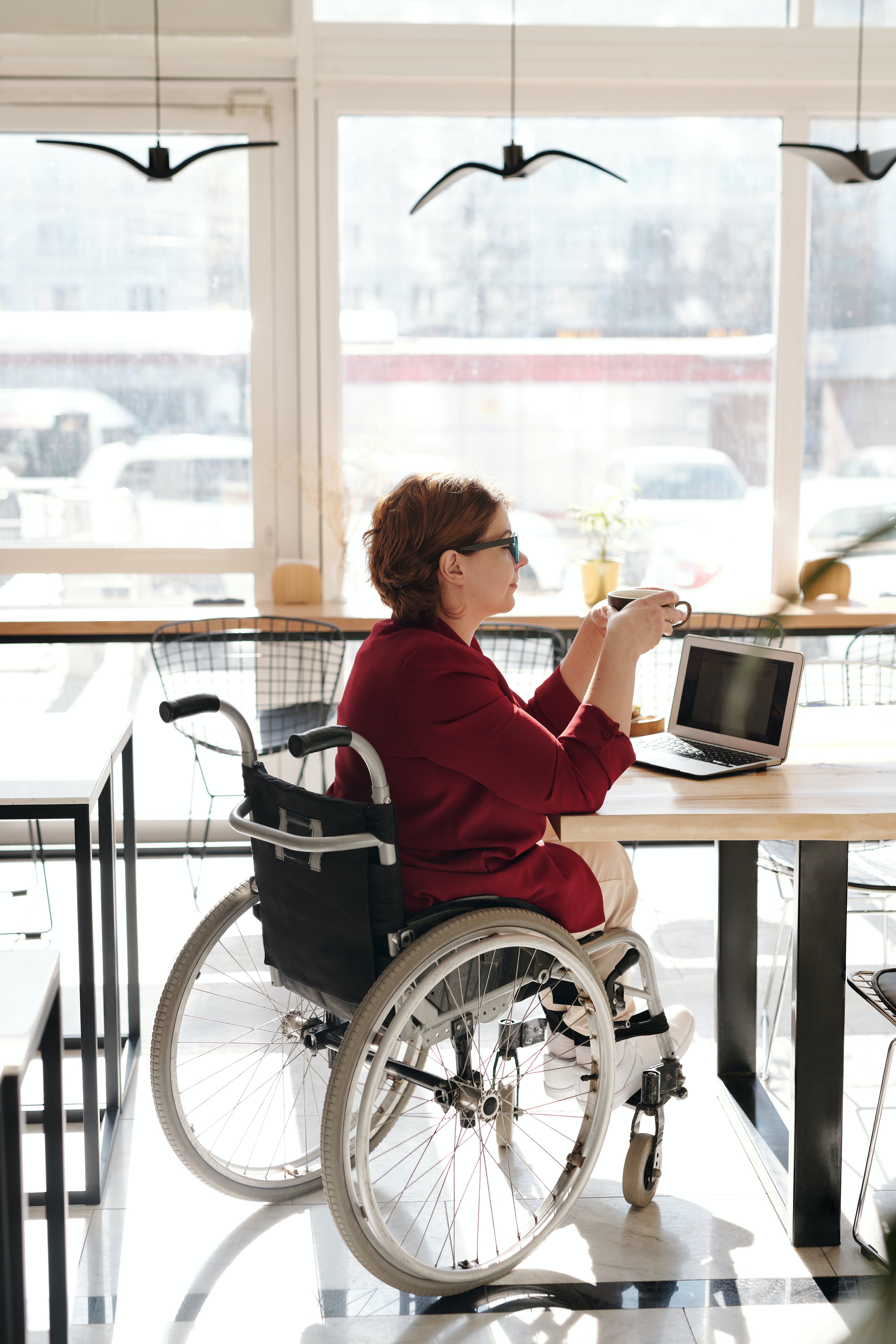 Noia amb cadira de rodes treballant amb un ordinador portàtil. Font: Pexels - Marcus Aurelius
