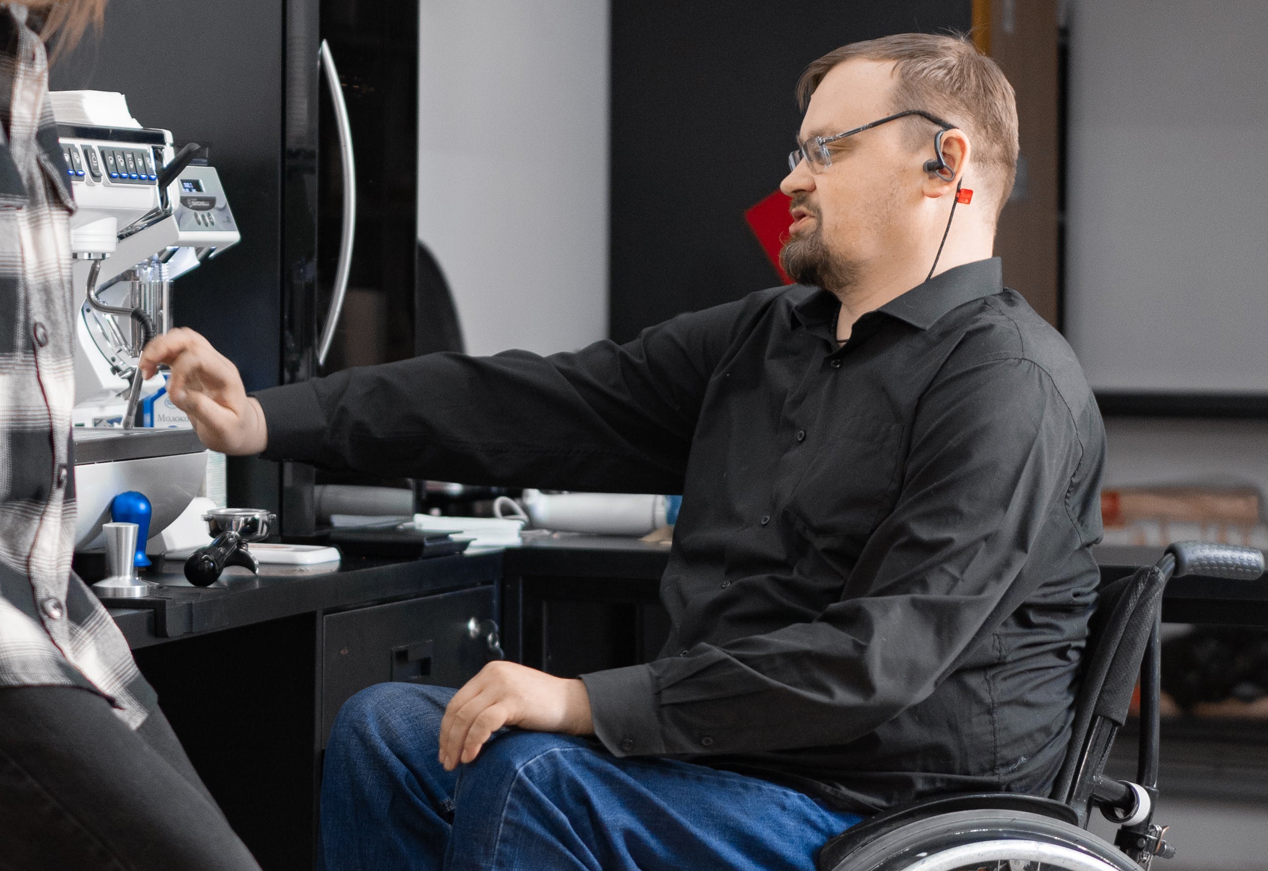 Persona amb cadira de rodes manipulant una màquina. Font: Pexels - Mikhail Nilov