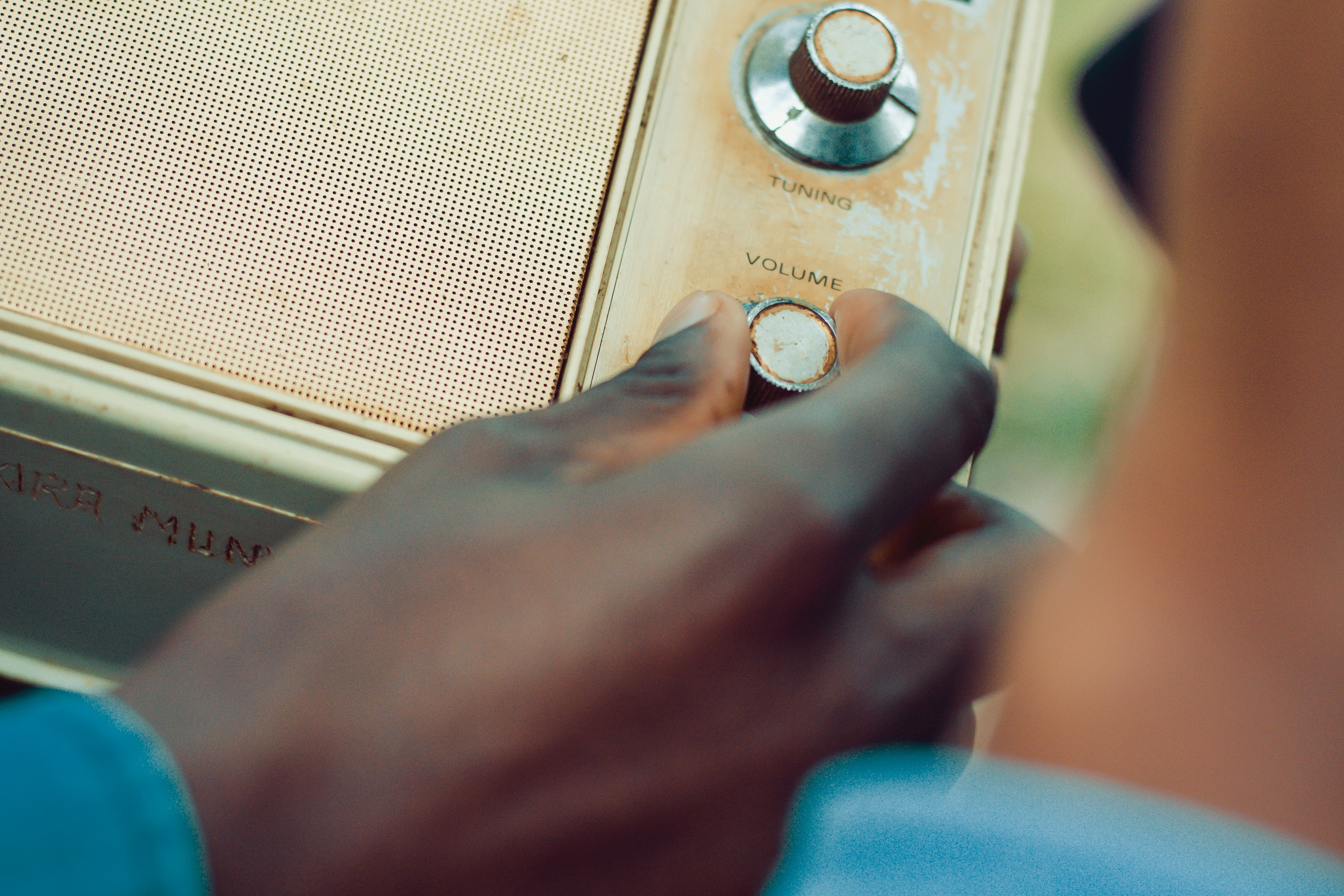 Una persona apujant el volum d'un receptor de ràdio antic. Font: Nicholas Githiri (Pexels)