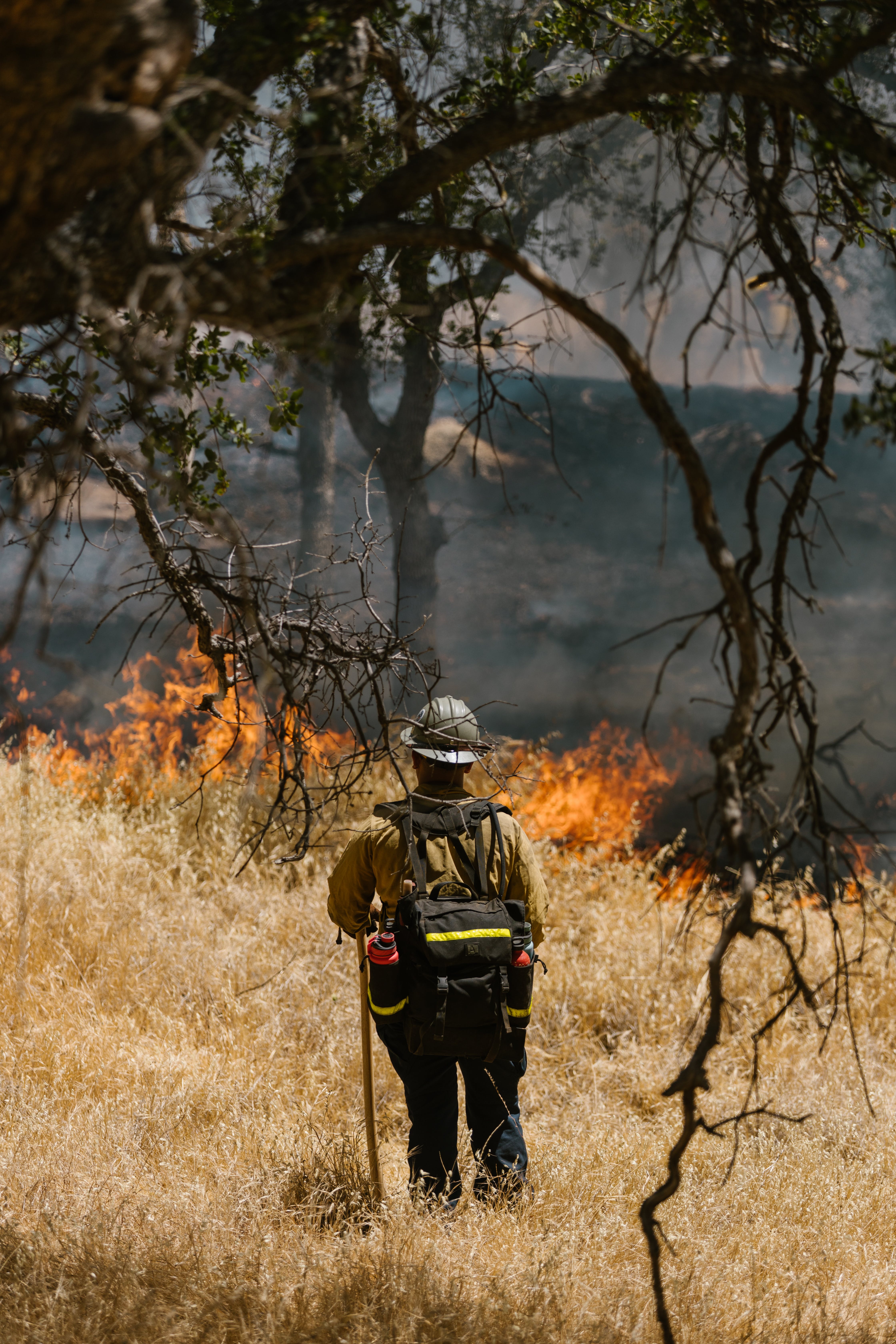 Persona bombera controlant un foc. Font: Pexels - RDNE Stock project