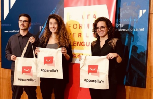 Tres participants en la iniciativa mostren bosses de roba amb el seu logotip
