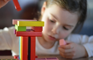 Una nena juga amb un joc de construcció.