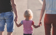 Una família camina, agafant de la mà a la seva filla. Font: Pixabay