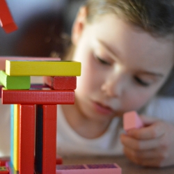 Un infant juga amb un joc de construccions.