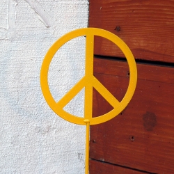 Símbol de la pau de color groc en una porta marró i blanca