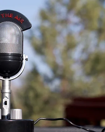 Micròfon de ràdio antic sobre una taula al mig del camp