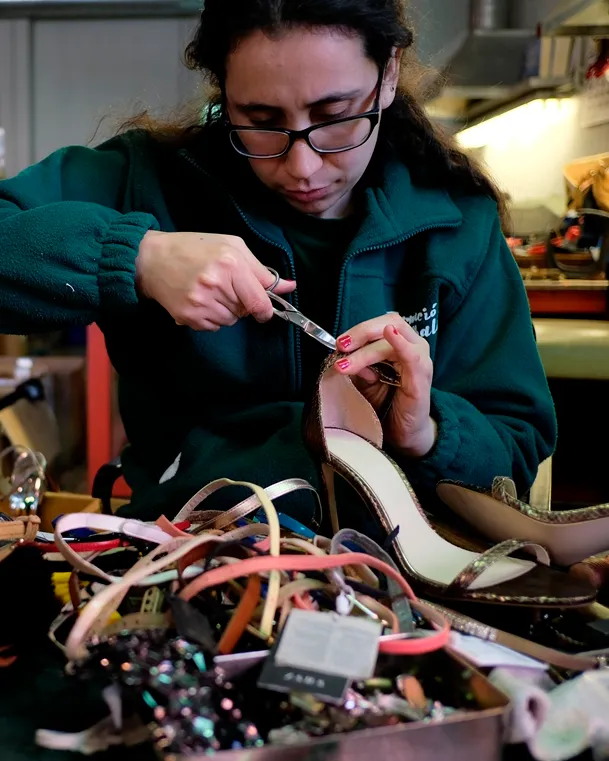 Un dona fabrica sabates en un taller