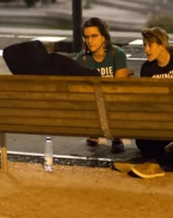 Persones oferint suport a una altra que dorm al carrer