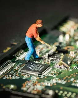 Fotografia d'una persona trencant una placa electrònica
